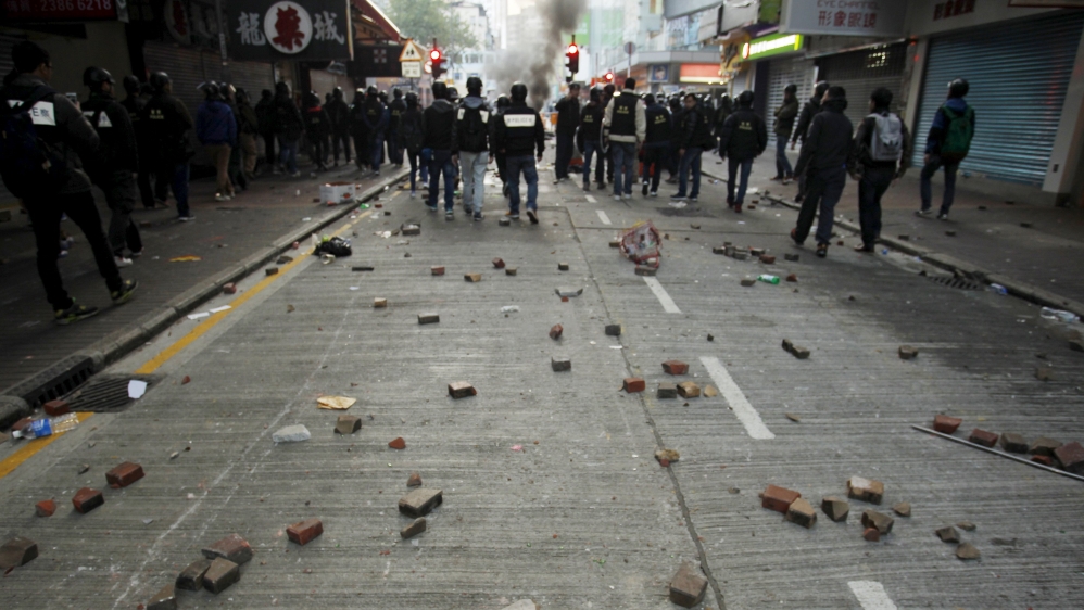 Bricks are seen behind riot police after a clash with protesters at Mongkok district in Hong Kong
