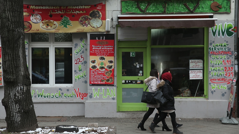 Young Muslim women walk past cafes, including one with signs in Arabic, in the ethnically diverse Neukoelln district which teems with a plethora of ethnicities, languages and religions [Sean Gallup/Getty Images]