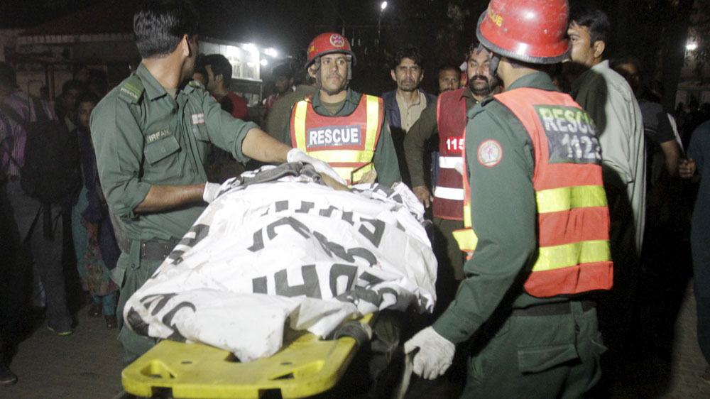 
Rescue workers move a body from the blast site [Mohsin Raza/Reuters]
