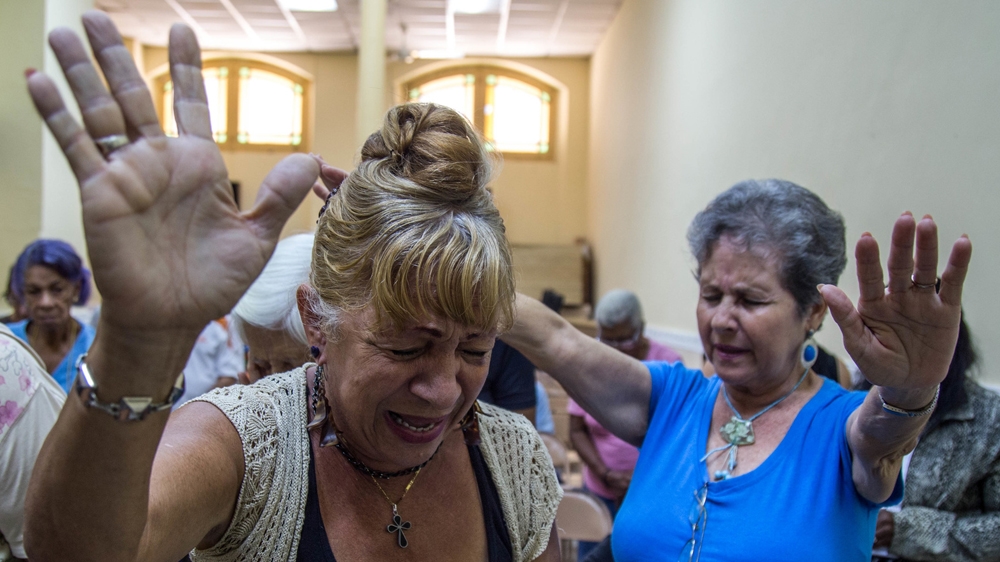 A prayer service reaches a crescendo at the First Baptist Church in Old Havana. The women ask God to save the 'lost youth' of Cuba  [Tomas Ayuso/Al Jazeera] 