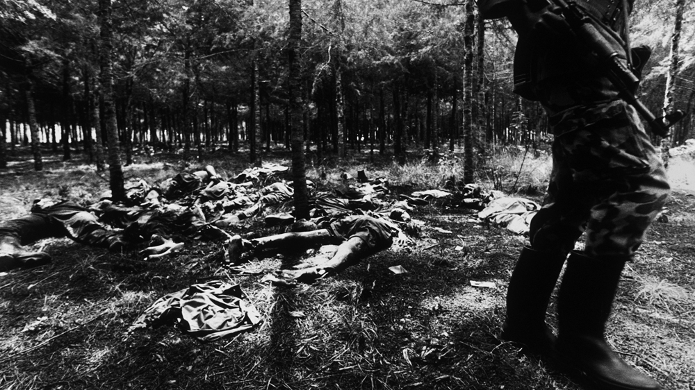 An RPF officer surveys a murder site [Jack Picone/Al Jazeera]
