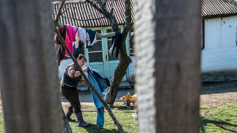 Oprea, however, still needs to wash clothes by hand as the solar panel doesn't provide enough power to run a washing machine [Felix Gaedtke/Al Jazeera] 