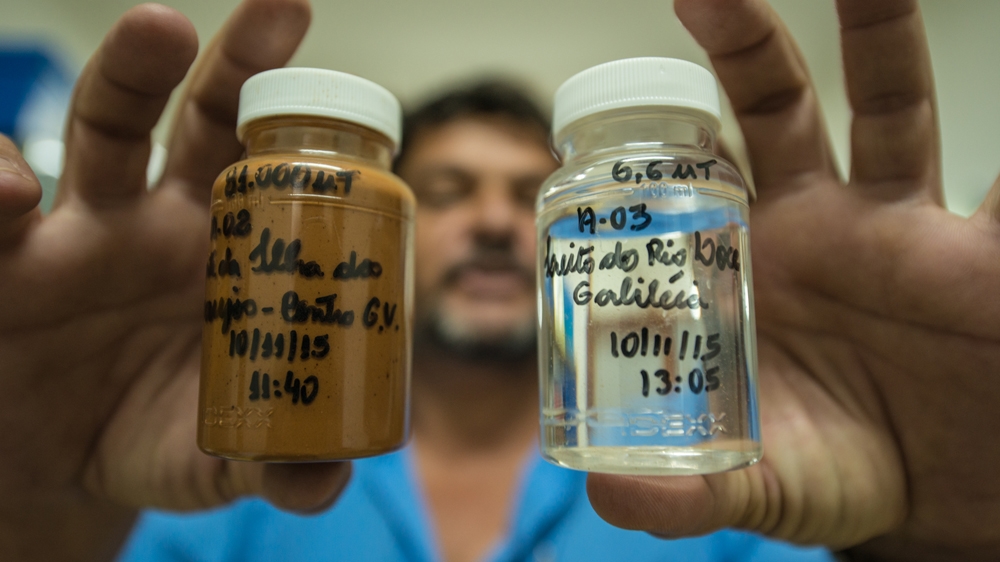 Luciano de Bem Magalias presents his water samples from the River Rio Doce before and after the mining sludge [Fabio Nascimento/Al Jazeera]