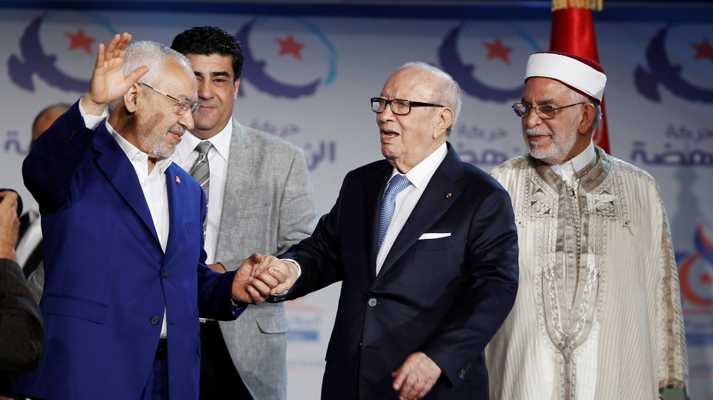 Tunisian President Beji Caid Essebsi (R) and Rached Ghannouchi, leader of the Islamist Ennahda movement, gesture during the congress of the Ennahda Movement in Tunis,Tunisia