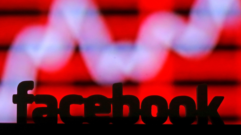 A 3D printed Facebook logo is seen in front of a displayed stock graph in this illustration taken