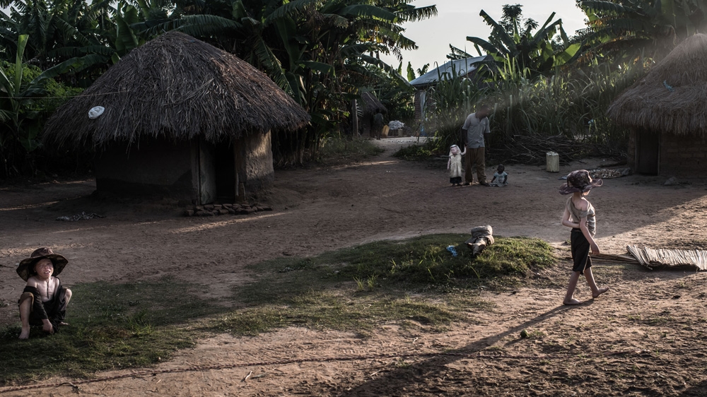 Mwanje Bernard, left, and Semabulia Julius, right. Mwanje and his two youngest children, Naburja and Marry, are in the background [Fredrik Lerneryd/Al Jazeera]