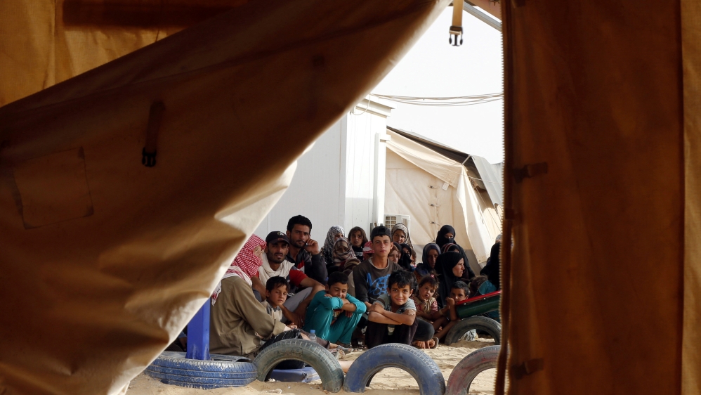 Syrian refugees wait to board a Jordanian army vehicle after crossing into Jordanian territory with their families, in Al Ruqban border area, near the Jordanian border with Syria [REUTERS