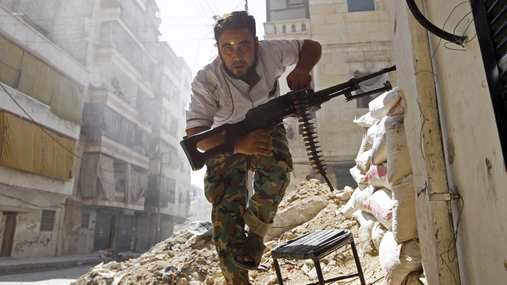 A Free Syrian Army fighter takes cover during clashes with Syrian Army in Aleppo