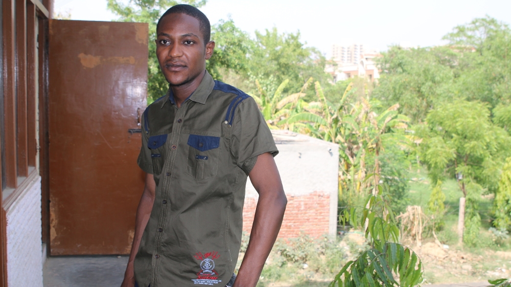Zaharaddeen Muhammed, a master's degree student from Nigeria, on the balcony of his home in Greater Noida, India [Aletta Andre/Al Jazeera]