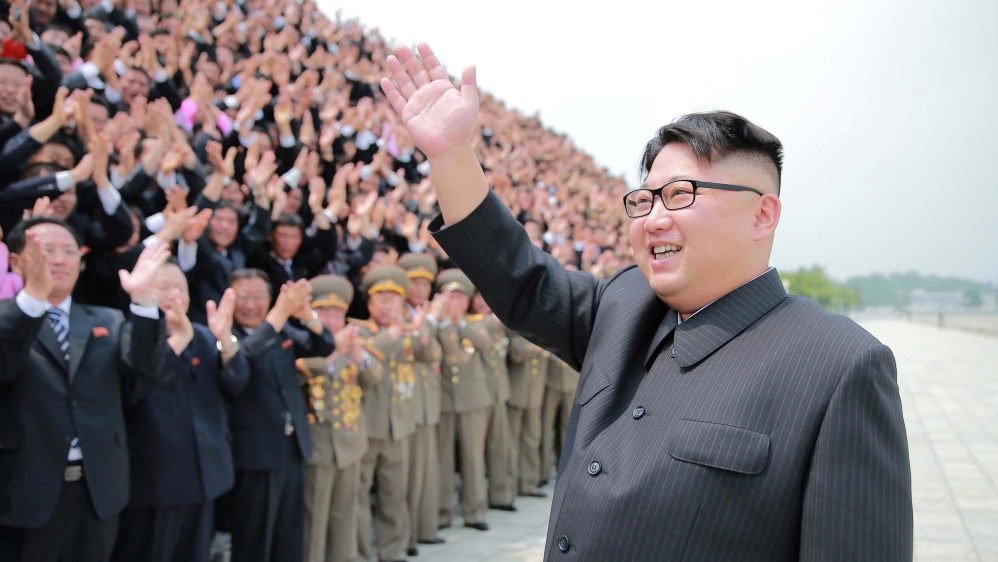 North Korean leader Kim Jong Un participates in a photo session with officials