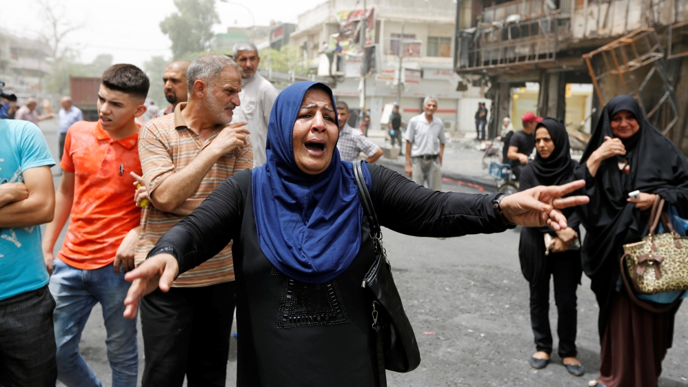A woman reacts at the site after a suicide car bomb attack at the shopping area of Karrada, a largely Shi''ite district, in Baghdad