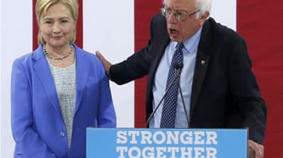 Bernie Sanders, right, reaches back as he endorses Hillary Clinton during a rally in Portsmouth, New Hampshire, July 12 [Reuters]
