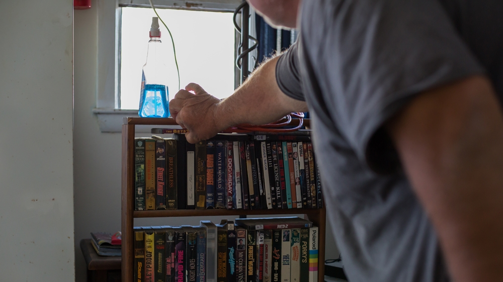  Scott's collection of videos and DVDs are the only way in which he has personalised his motel room [Carolyn Bick/Al Jazeera] 