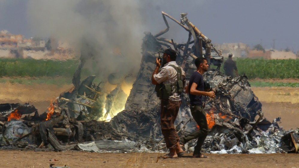 Men inspect the wreckage of a Russian helicopter that had been shot down in the north of Syria''s rebel-held Idlib province