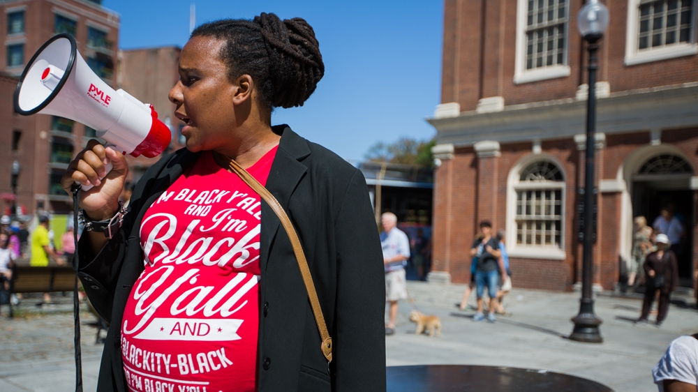 Nia Evans speaks to the crowd of protesters outside Faneuil Hall  [Carolyn Bick/Al Jazeera]  