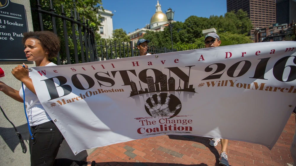 Lindsay Ladd, left, holds The Change Coalition's sign, as the group marches down the Freedom Trail  [Carolyn Bick/Al Jazeera]   