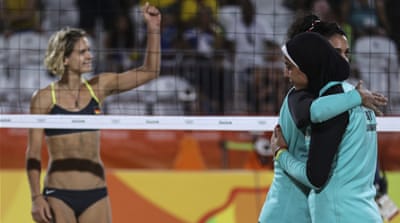 Nada Meawad, centre, and Doaa Elgobashy, right, of Egypt hug as Laura Ludwig of Germany gestures during the women's beach volleyball game [EPA]