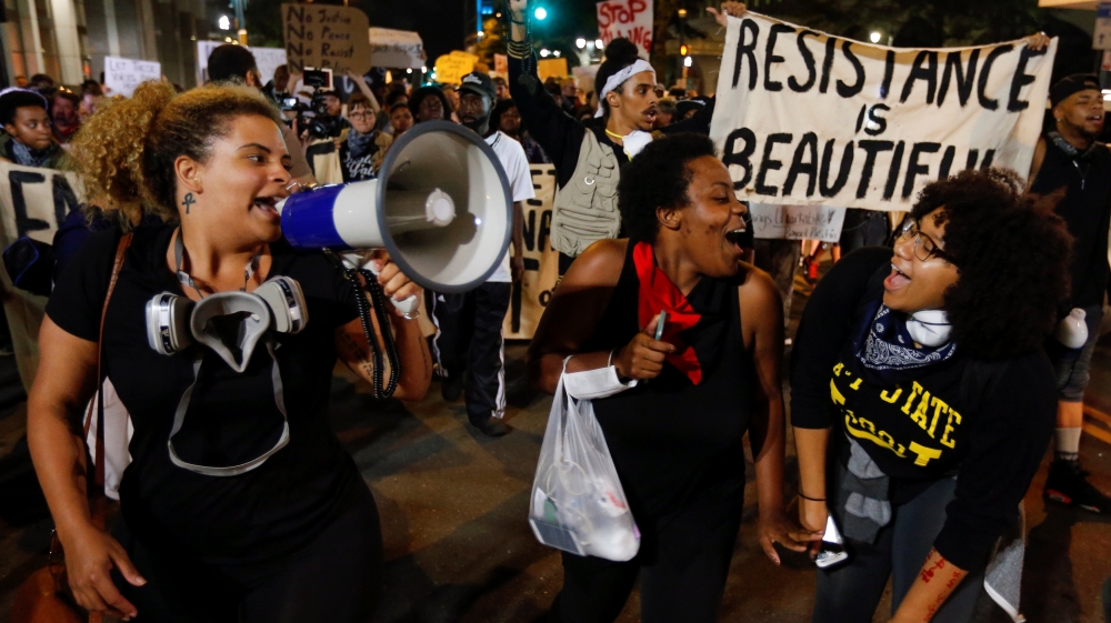 Marchers laugh with each other during a protest against the police shooting of Keith Scott, in Charlotte