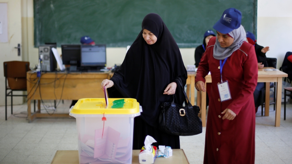A woman casts her ballot at a polling station for parliamentary elections in Amman