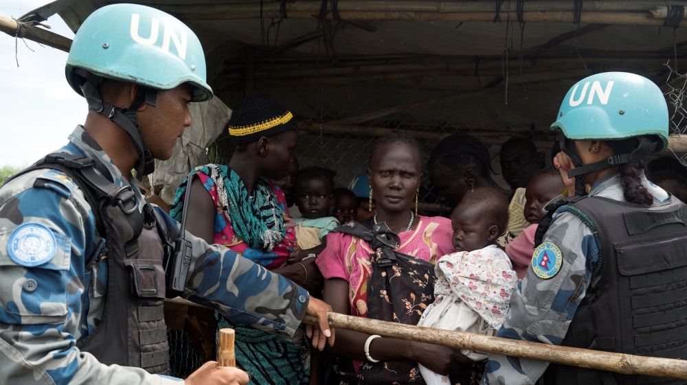 UN peacekeepers control South Sudanese women and children before the distribution of emergency food supplies in Juba, South Sudan [REUTERS]
