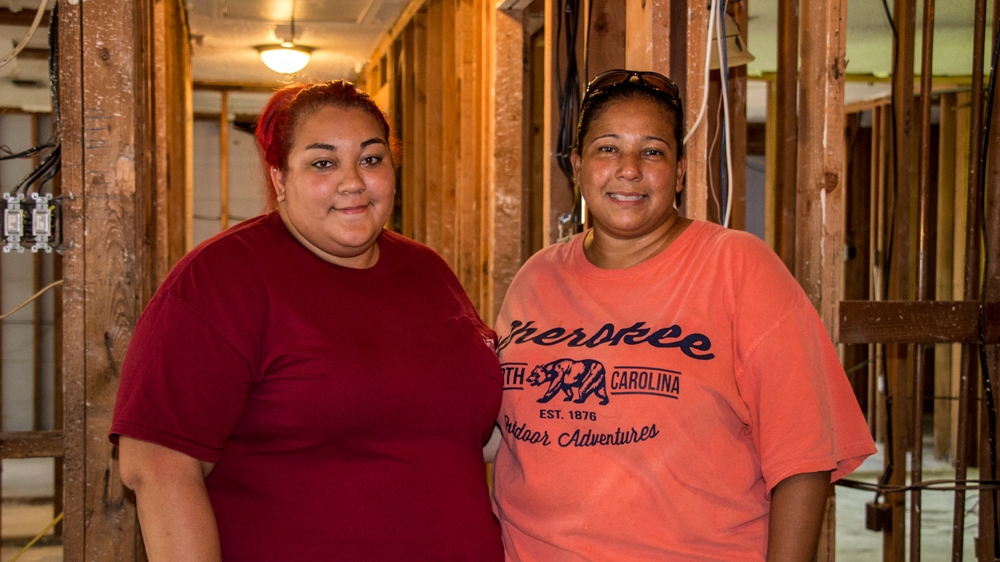 Mary Mercado, right, and her daughter Jackie come to their home each day to make sure nothing is stolen [Shaghayegh Tajvidi/Al Jazeera]