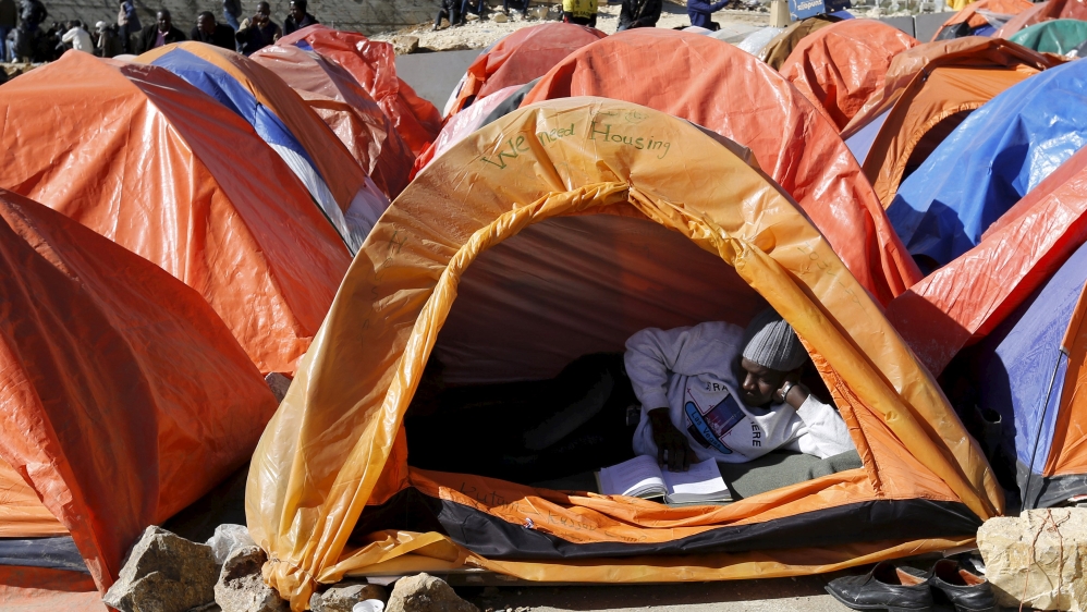 Sudanese refugees from Darfur sit near their tent in an open-ended sit-in in outside the UNHCR office, demanding better treatment and acceleration of their relocation, in Amman
