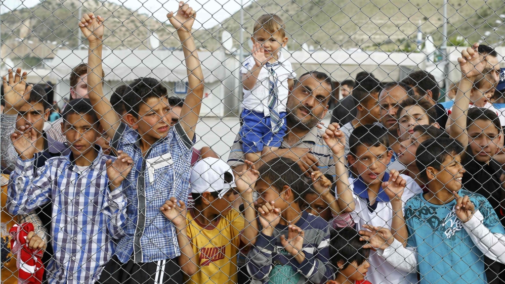 Refugees and their children wait for the arrival of officals at Nizip refugee camp near Gaziantep