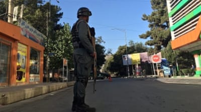 An Afghan security official secures the site of a third bomb blast that detonated near a guesthouse in Kabul [EPA]