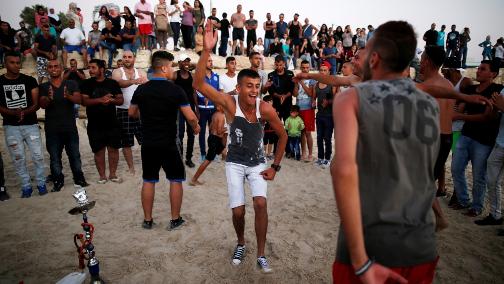 People enjoy themselves along the shore of the Mediterranean Sea during the Muslim holiday of Eid al-Adha at a beach in Tel Aviv