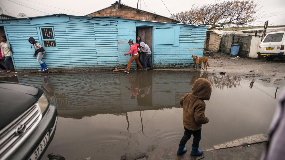  Children inch their way along the edge of a street after heavy rainfall in Langa, South Africa [David Harrison/The Times /Gallo Images/Getty Images] 