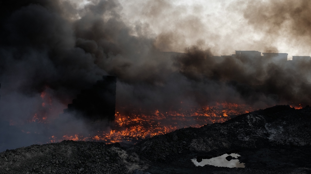 On some days, the black smoke is so thick that it appears to be pitch dark at midday [Benedetta Argentieri/Al Jazeera]