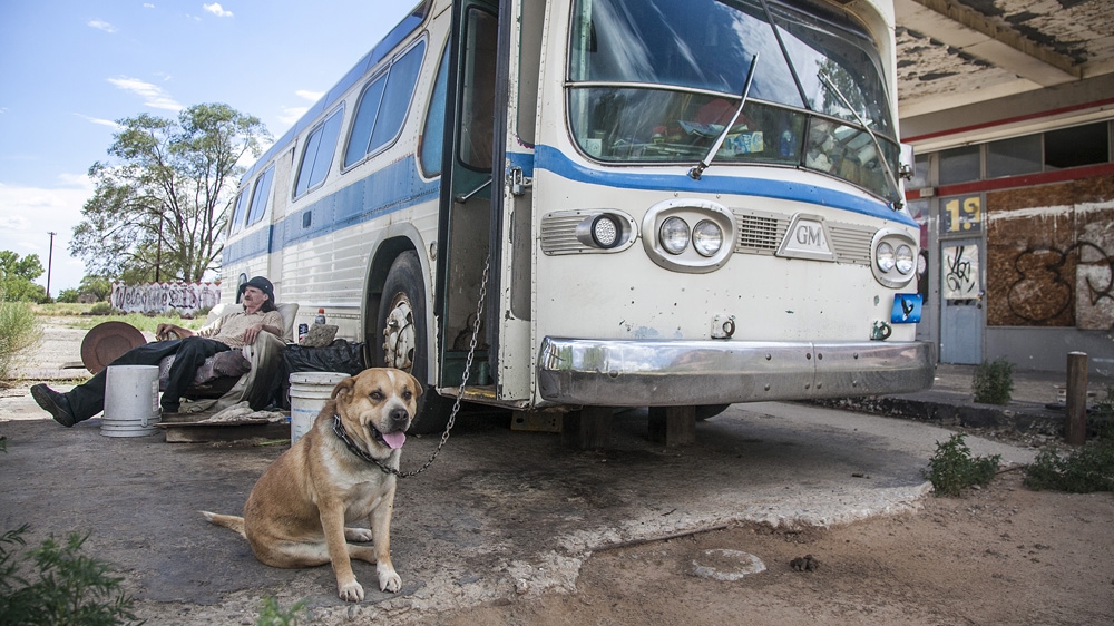 A man and his pets taking up residence in the old Indian Market store trading post [Gabriela Campos/Al Jazeera]