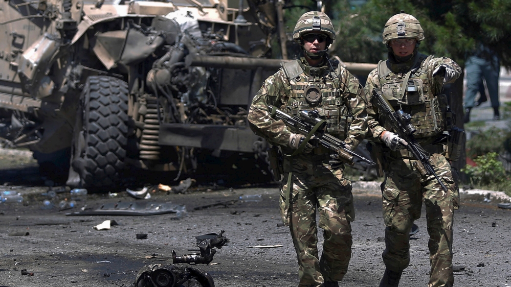 NATO soldiers walk at the site of a suicide bomb attack in Kabul, Afghanistan