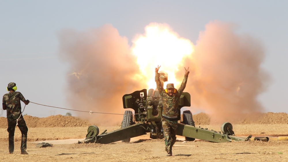 Popular Mobilization Forces (PMF) personnel fire artillery during clashes with Islamic State militants south of Mosul