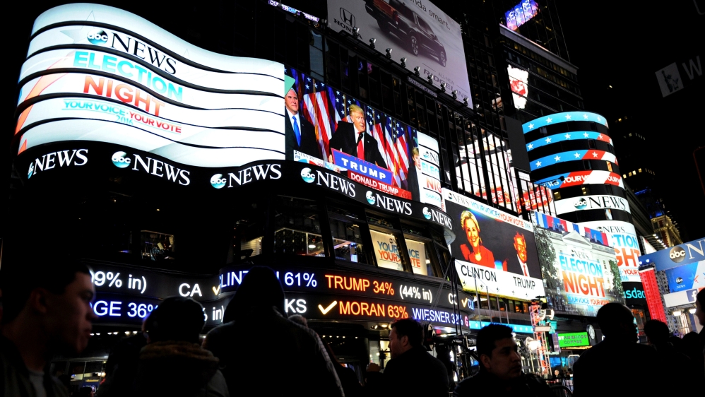 People watch as U.S. president-elect Donald Trump is displayed speaking, in Times Square in New York