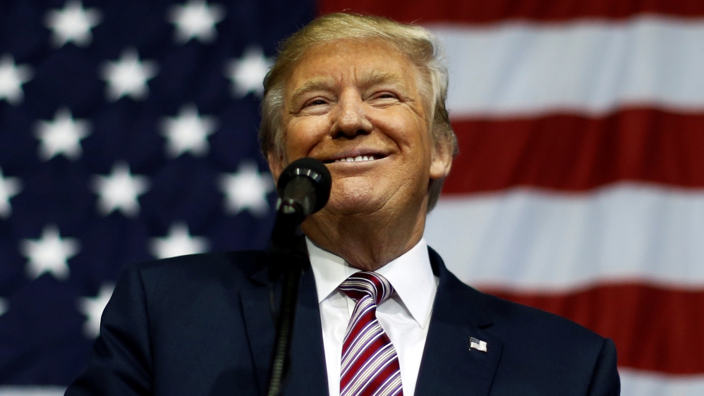 U.S. Republican presidential nominee Trump smiles after making what he said was a major announcement, that he''d abide by the election results if he won, to supporters at a camp