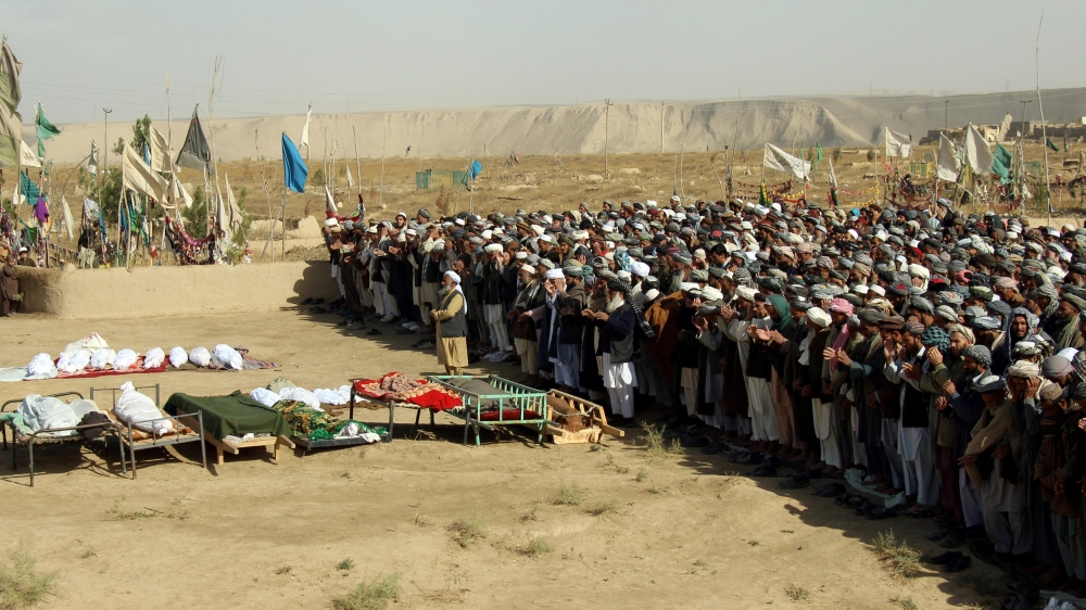 Afghans perform prayers at the funeral for the victims killed by an air strike called in to protect Afghan and U.S. forces during a raid on suspected Taliban militants, in Kunduz