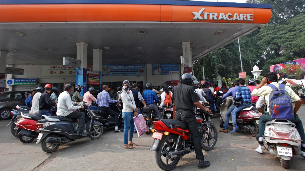 People queue as they wait for their turn to fill fuel at a petrol pump in Lucknow