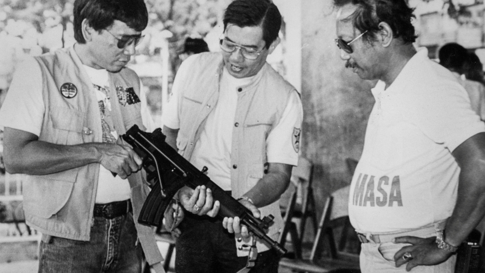 Mayor Rodrigo Duterte inspects an assault rifle in Davao city in the southern Philippines