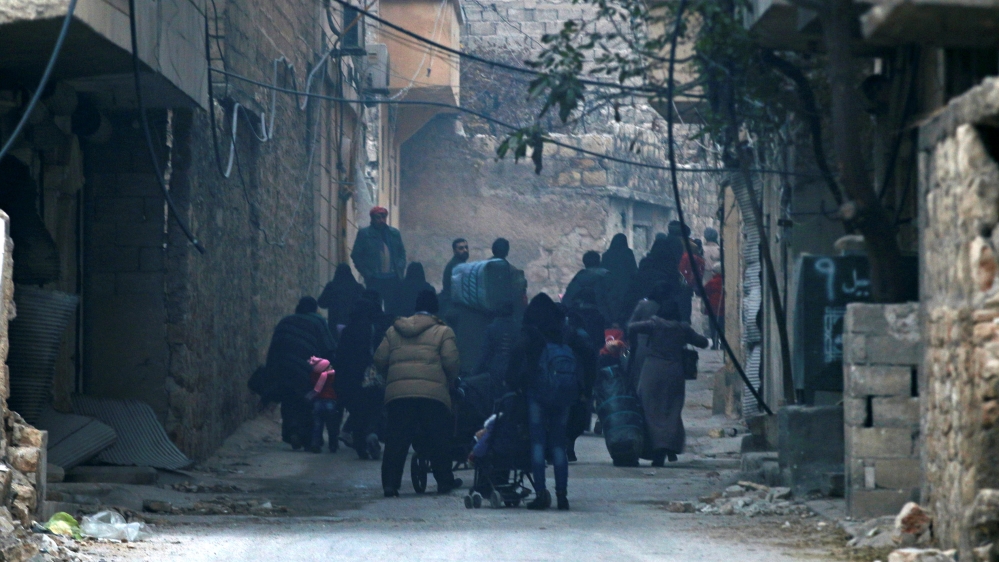 People carry belongings as they flee deeper into the remaining rebel-held areas of Aleppo