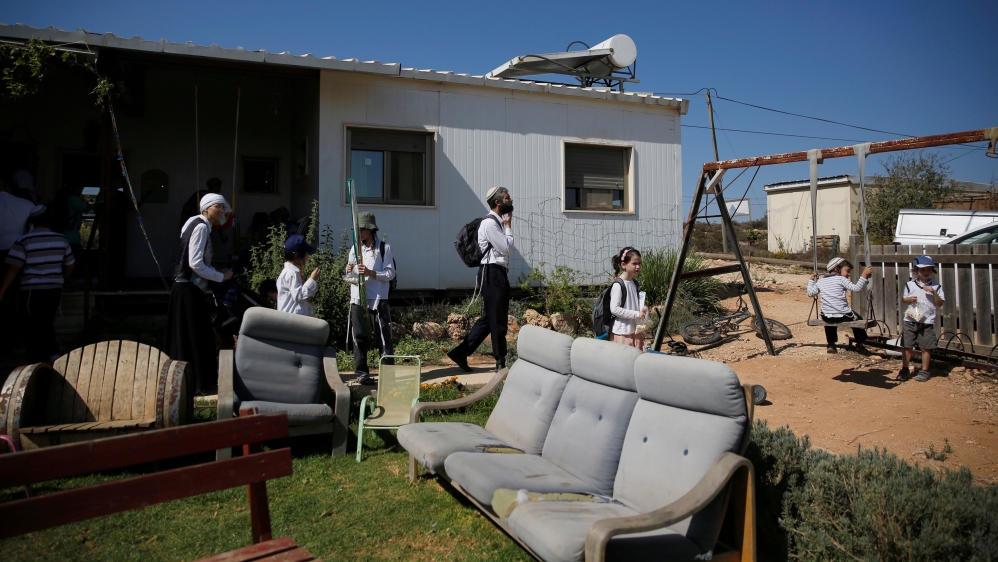 Visitors walk in a yard near a home in the Jewish settler outpost of Amona in the West Bank, during an event organised to show support for Amona