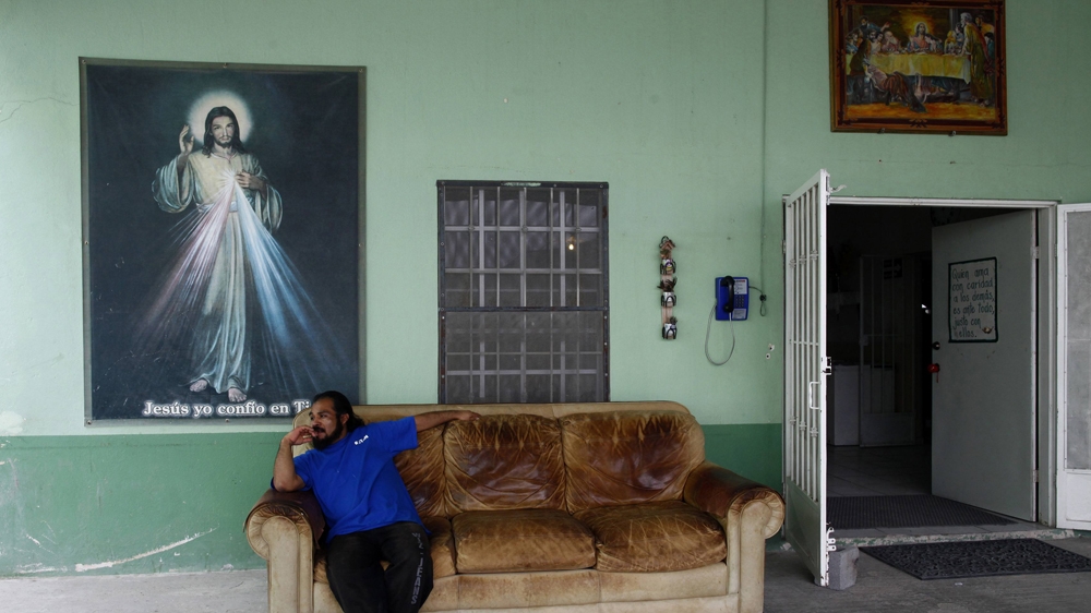 A man sits on a couch at Casa del Migrante in Reynosa, Mexico