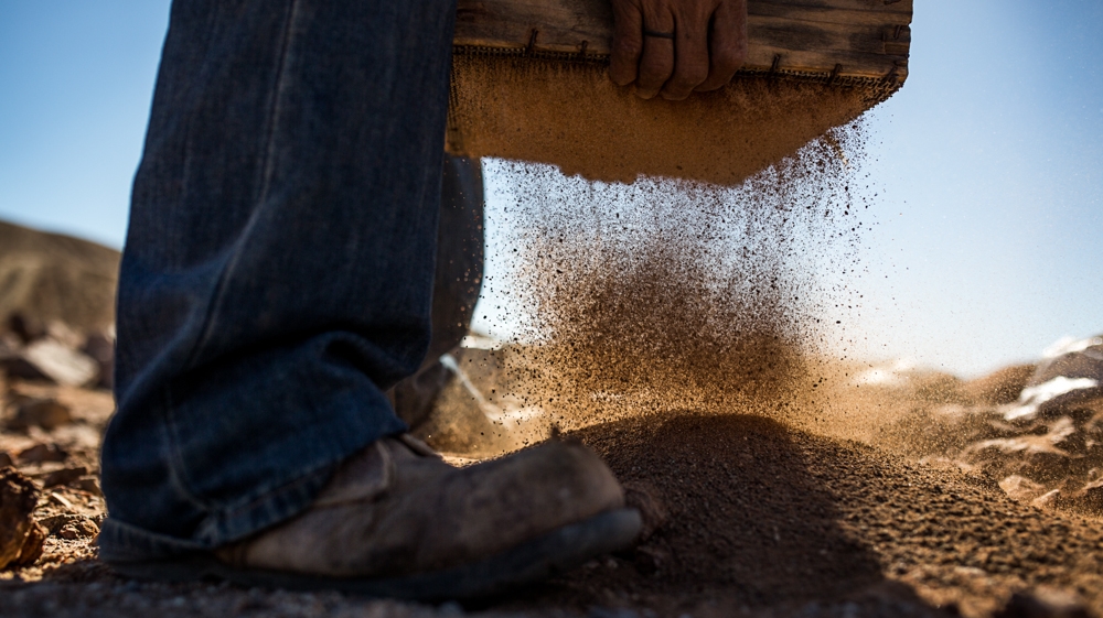 South Africa's artisanal miners spend their days searching for diamonds in the vast landscape while evading capture by private security guards or the police  [ Shaun Swingler/Al Jazeera ]