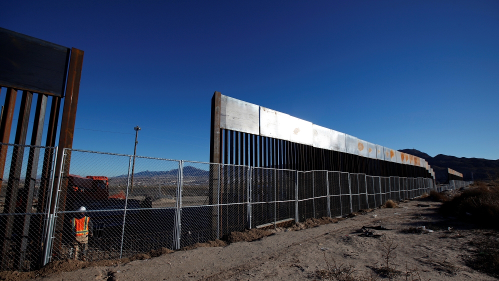A worker stands next to a newly built section of the U.S.-Mexico border fence at Sunland Park, U.S. opposite the Mexican border city of Ciudad Juarez