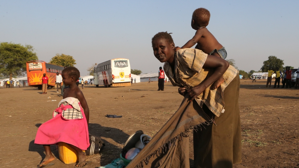 A refugee mother from South Sudan prepares to carry her child on her back on arrival at Bidi Bidi refugee’s resettlement camp near the border with South Sudan, in Yumbe district