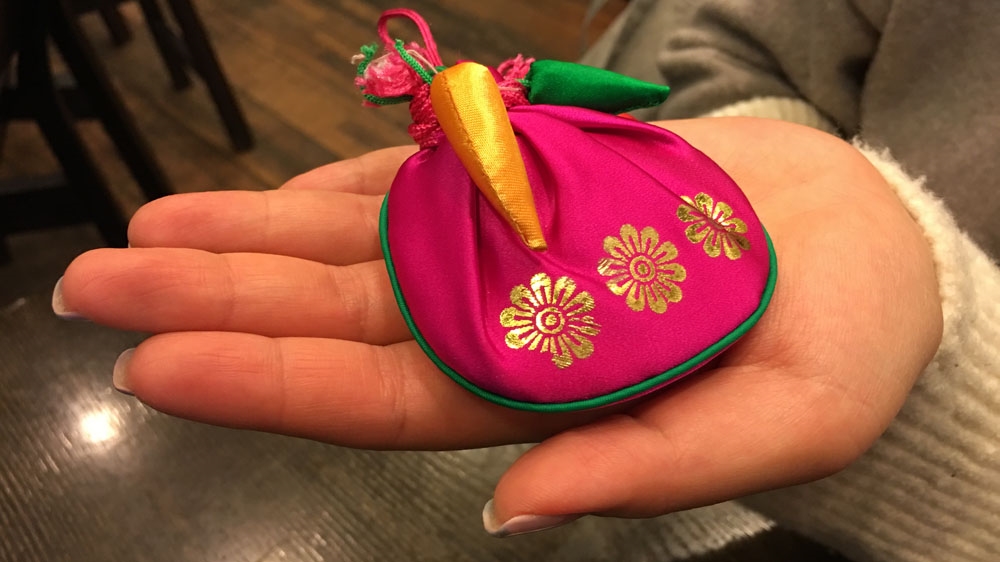 Women are instructed not to remove the love amulet from its pouch or it will lose its power [Jason Strother/Al Jazeera]