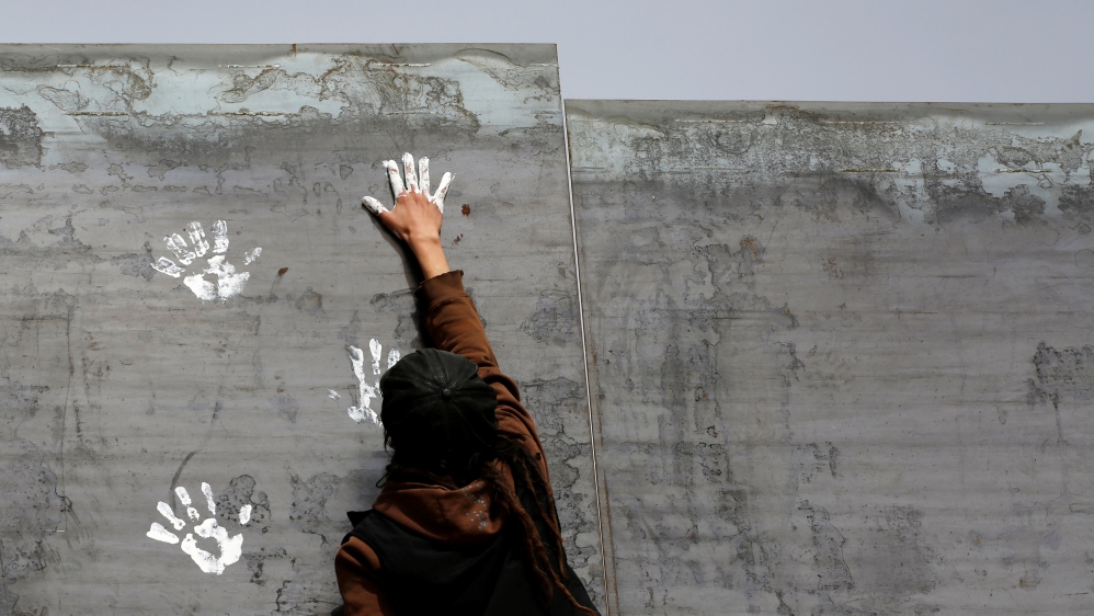 Activist paints the U.S.-Mexico border wall between Ciudad Juarez and New Mexico as a symbol of protest against US President Donald Trump''s new immigration reform in Ciudad Juarez, Mexico