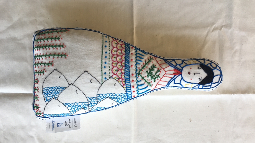 Falak's doll is decorated with fish, representing her daughter Amal's fear of travelling by sea [Courtesy of the Ana Collection/Al Jazeera]