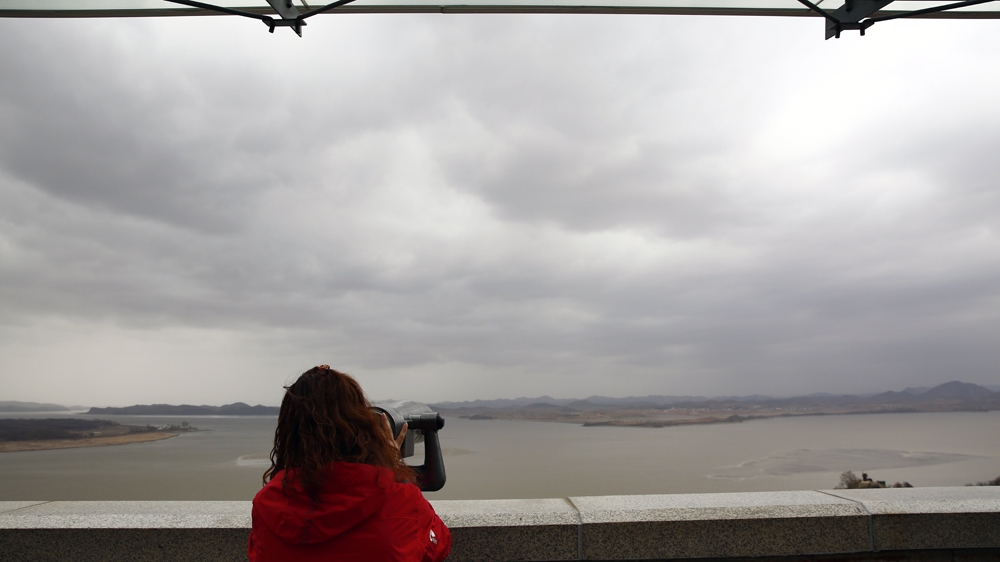 A South Korean visitor looks the Gaepung-gun county on the North Korean side of the Military Demarcation Line