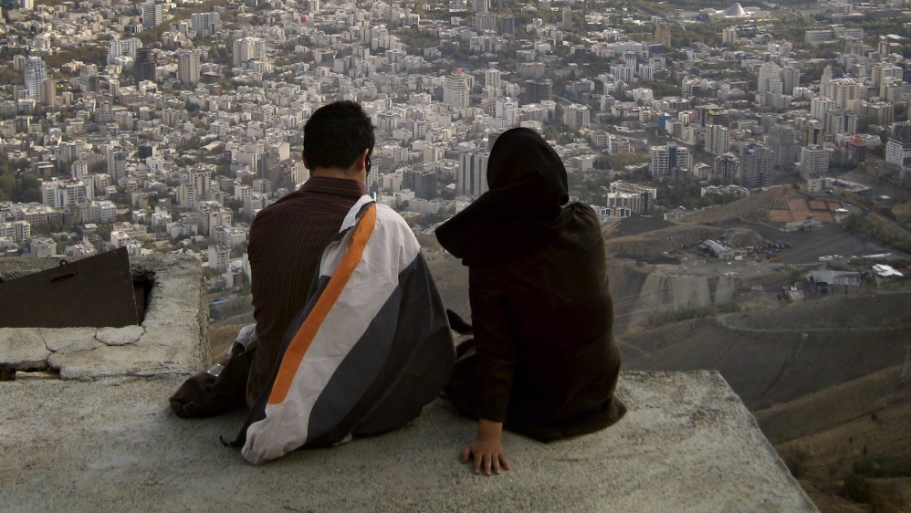 File photo of an Iranian couple sitting, overlooking the city of Tehran